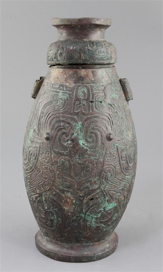 A Chinese archaic bronze ritual drinking vessel and cover, Hu, Western Zhou dynasty, 11th-9th century B.C., 30cm high, faults